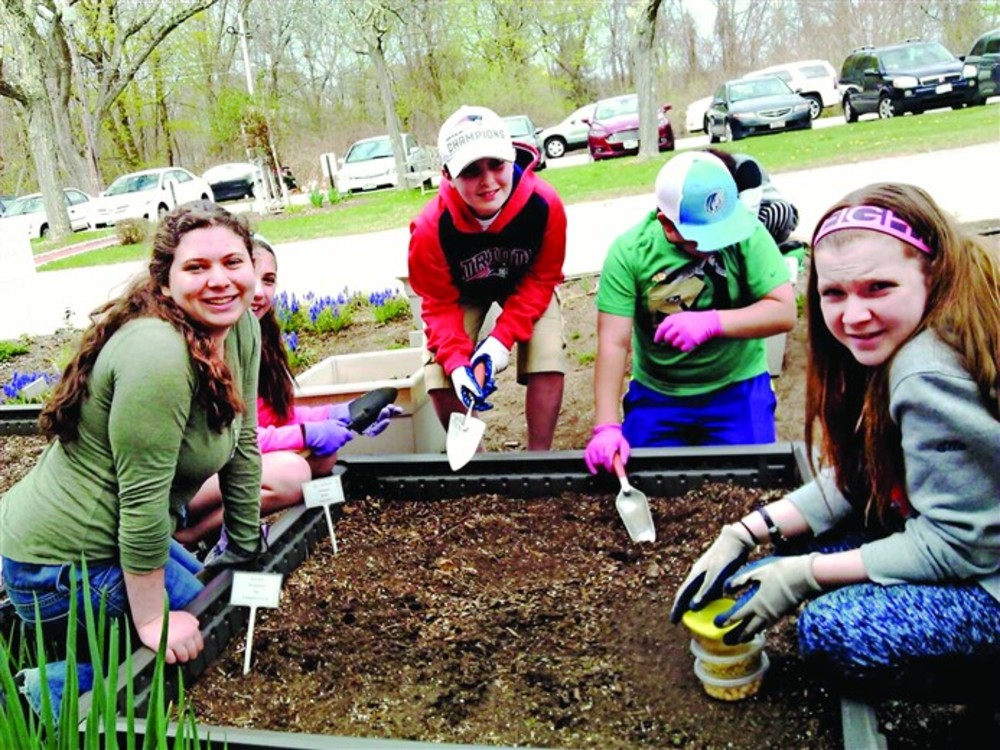 Religious school students from Temple Sinai help out in the garden. /Catherine Walters